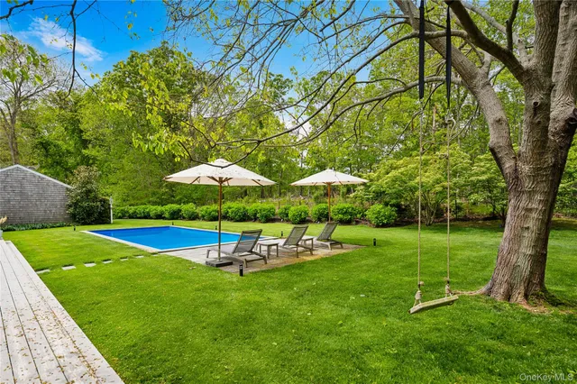 a swimming pool with outdoor seating and yard