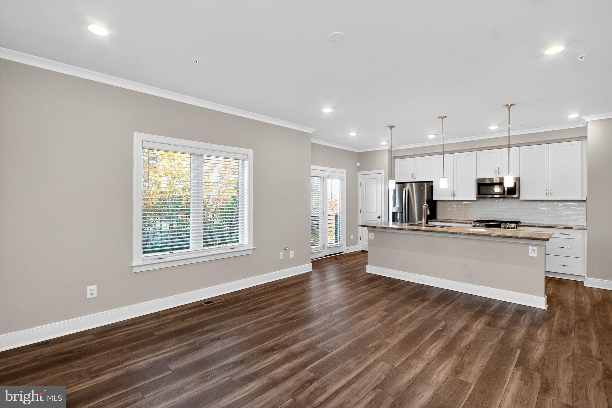 1322 Rail Woodbridge, VA 22191 - Photo 11 of 30 a large kitchen with stainless steel appliances granite countertop a large window a oven and white cabinets with wooden floor