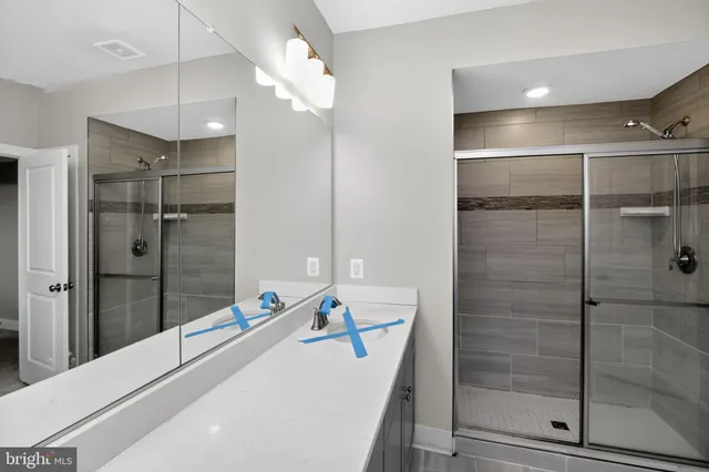 a bathroom with a tub shower vanity and sink