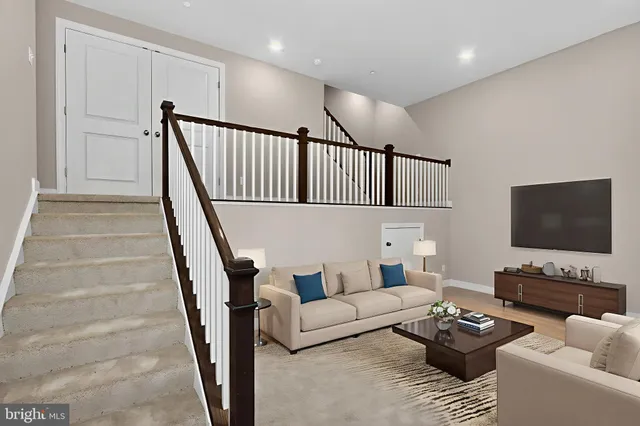 a living room with furniture and a flat screen tv with wooden floor