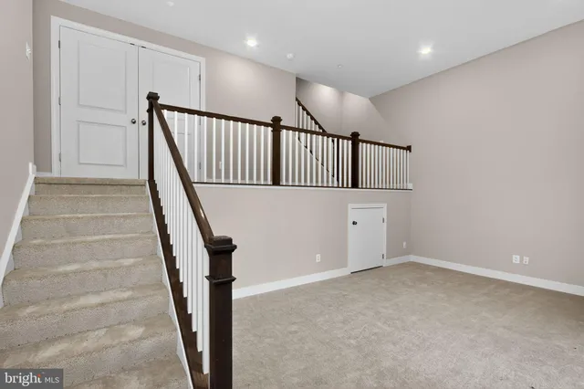a view of staircase with white walls and railing