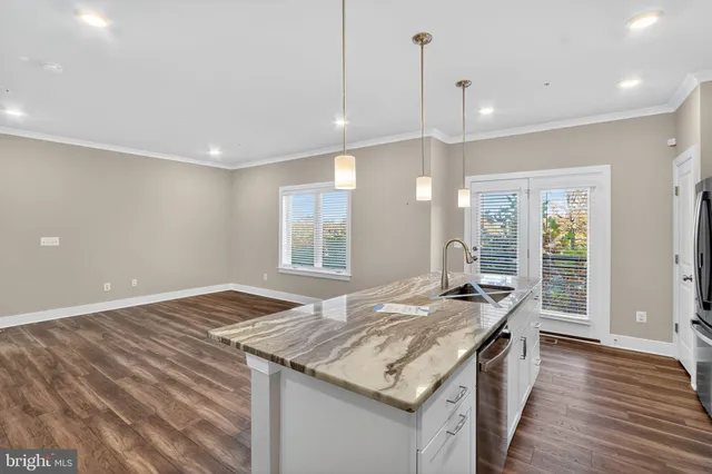 a kitchen with granite countertop sink stove and wooden floor