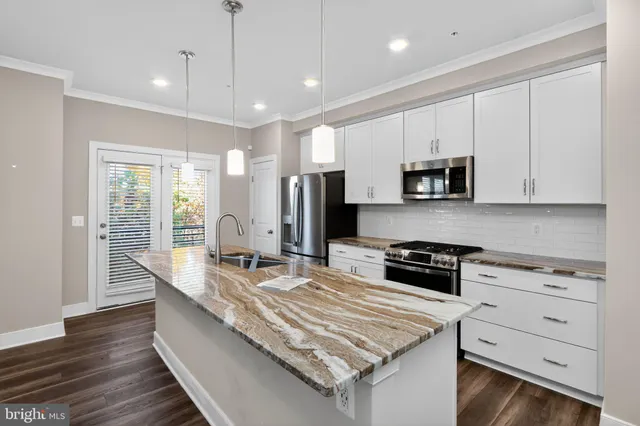 a kitchen with kitchen island granite countertop a sink a stove and cabinets