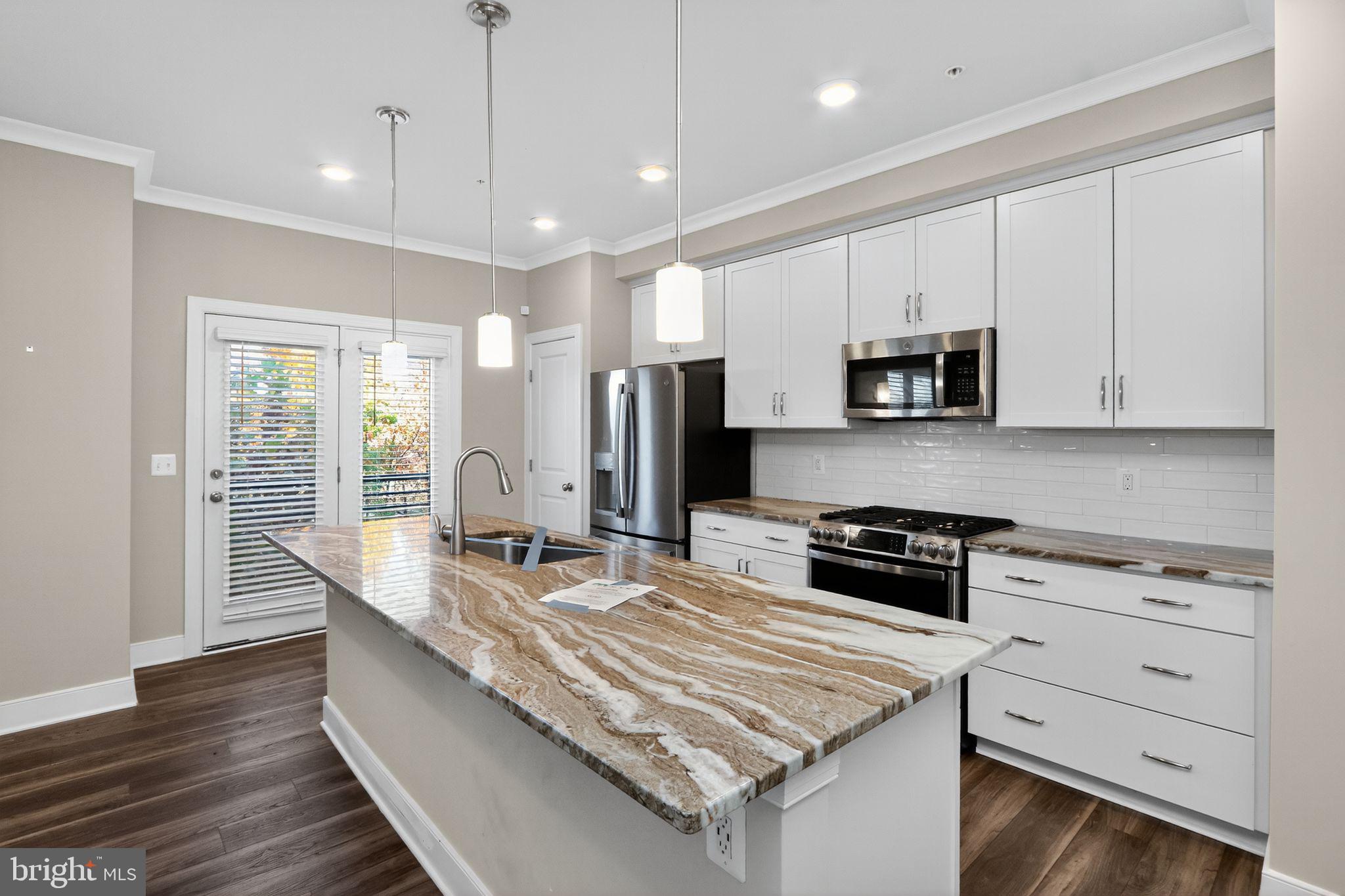1322 Rail Woodbridge, VA 22191 - Photo 9 of 30 a kitchen with kitchen island granite countertop a sink a stove and cabinets