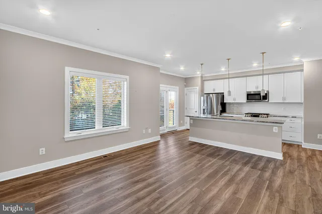 a view of kitchen with granite countertop cabinets and refrigerator