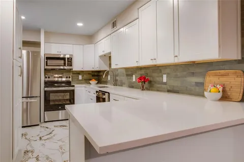 a kitchen with stainless steel appliances a refrigerator sink and microwave