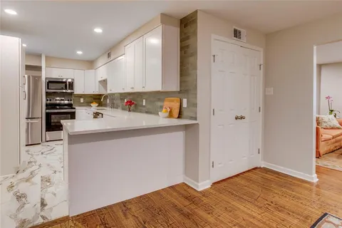 a kitchen with stainless steel appliances a refrigerator and a stove top oven