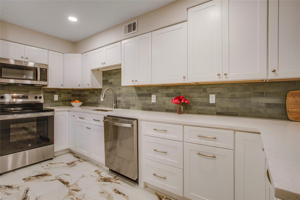 7777 Royal Lane Dallas, TX 75230 - Photo 10 of 30 a kitchen with granite countertop white cabinets stainless steel appliances and a sink