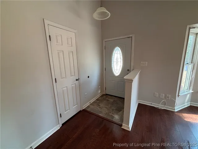 an empty room with wooden floor mirror and staircase