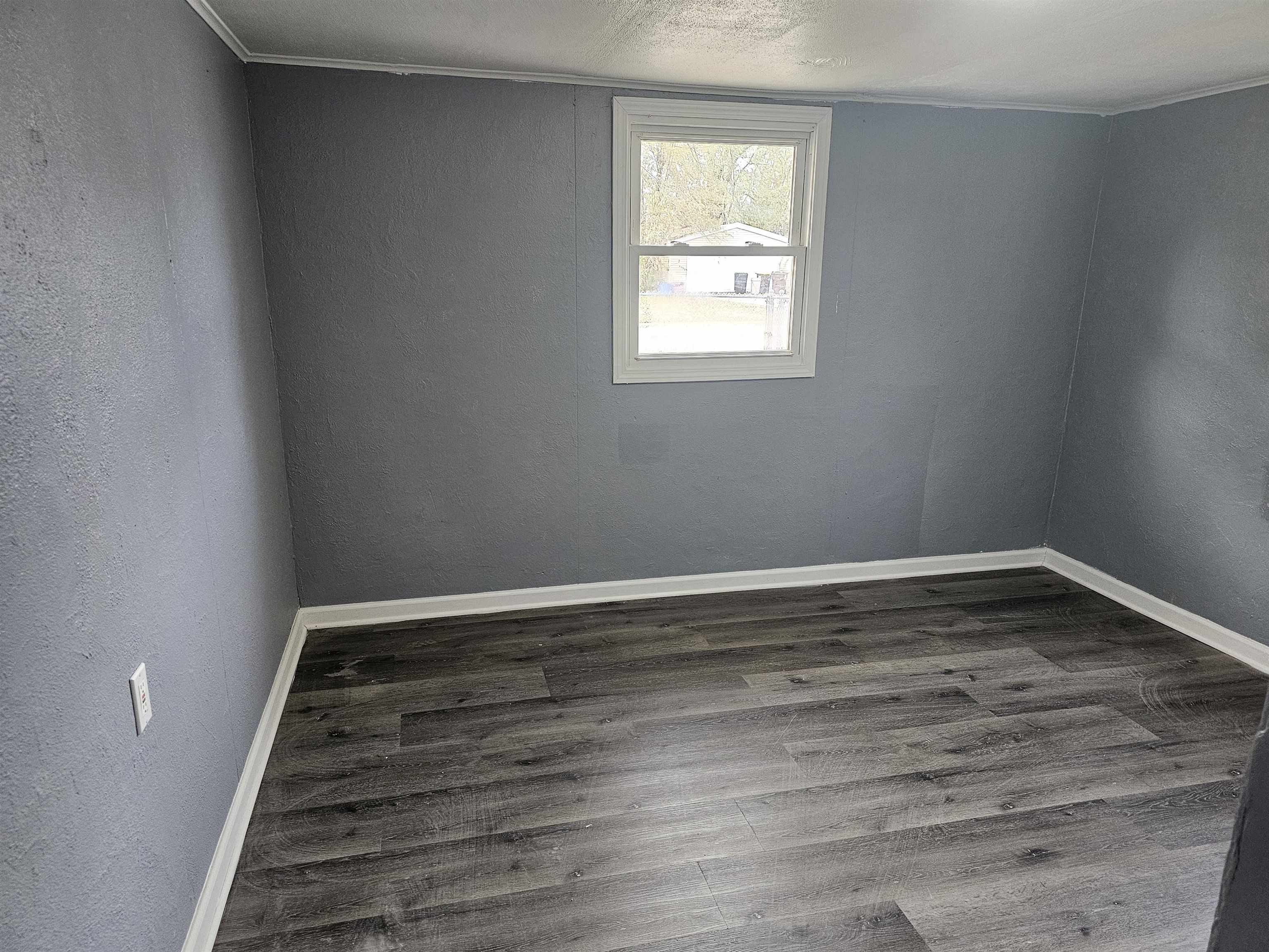 7913 Mildred Road Machesney Park, IL 61115 - Photo 13 of 20 a view of an empty room with wooden floor and a window
