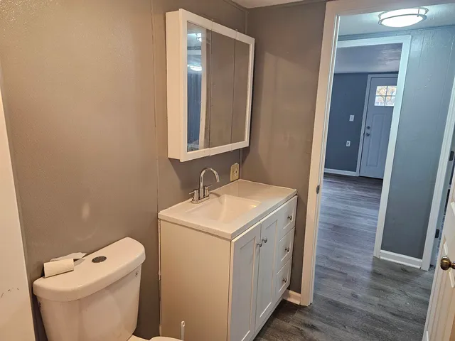 a bathroom with a toilet sink and mirror
