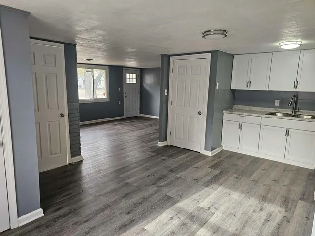 a view of a kitchen with wooden floor and a window