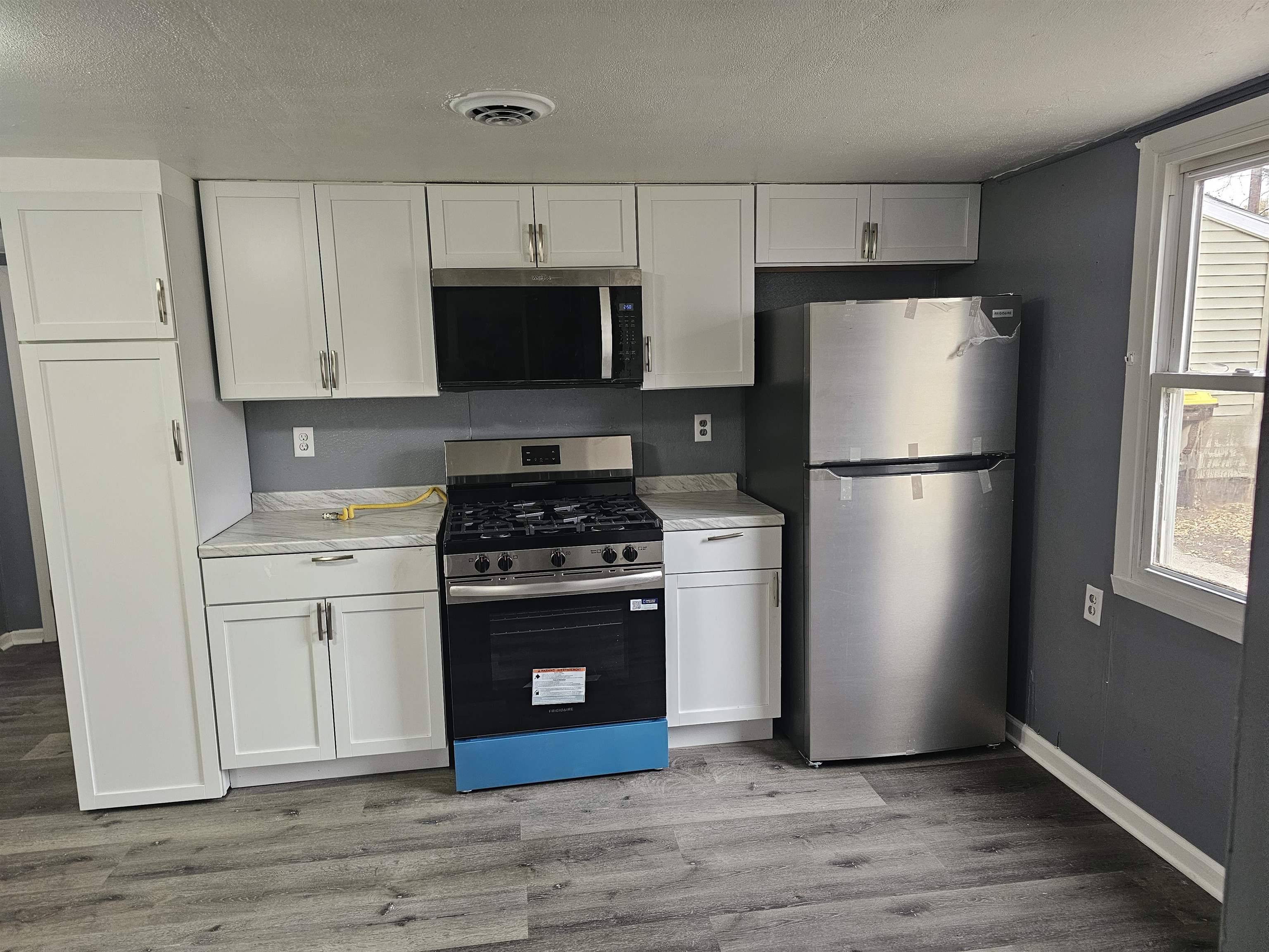7913 Mildred Road Machesney Park, IL 61115 - Photo 7 of 20 a kitchen with a refrigerator stove and white cabinets