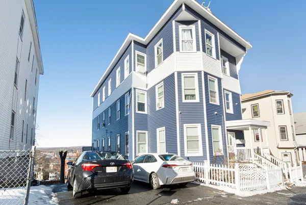 a couple of cars parked in front of a house