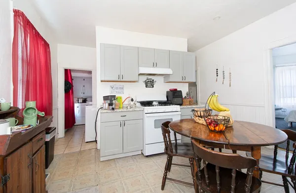 a kitchen with stainless steel appliances granite countertop a dining table and chairs