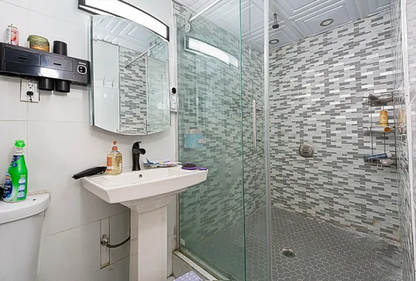 a bathroom with a sink a toilet and shower