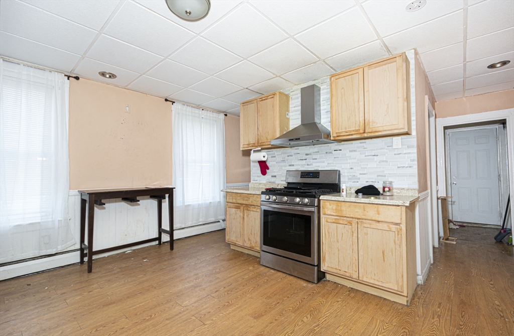 109 Merrifield Street Worcester, MA 01605 - Photo 20 of 21 a kitchen with stainless steel appliances granite countertop a stove a sink and a refrigerator