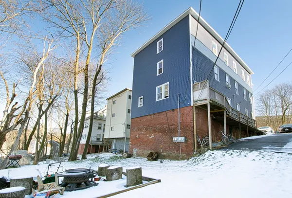 a front view of a building with large trees