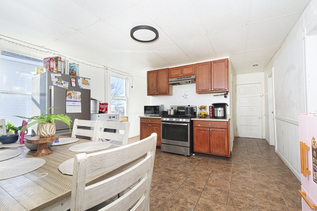 109 Merrifield Street Worcester, MA 01605 - Photo 5 of 21 a kitchen with stainless steel appliances kitchen island granite countertop a stove and a sink