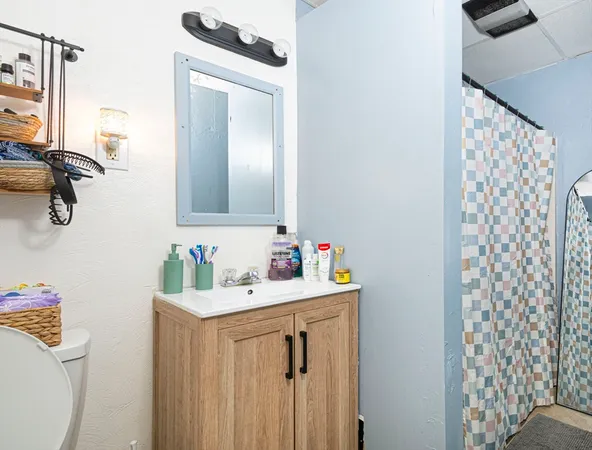 a bathroom with a sink vanity mirror and toilet