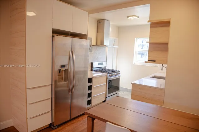 a kitchen with white cabinets and stainless steel appliances