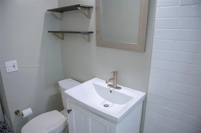 a bathroom with a sink a toilet and mirror