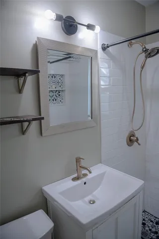 a bathroom with a sink a toilet and shower