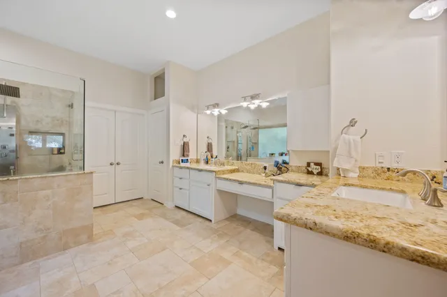 a large bathroom with a sink a large mirror and a bath tub