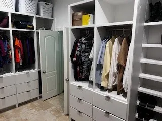 a view of walk in closet with clothes and shoes