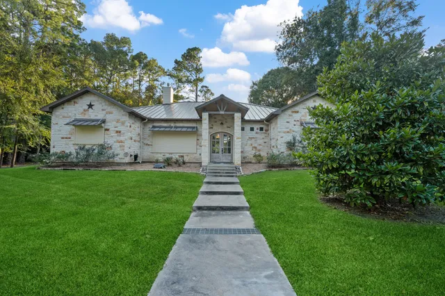 a front view of a house with a yard and potted plants