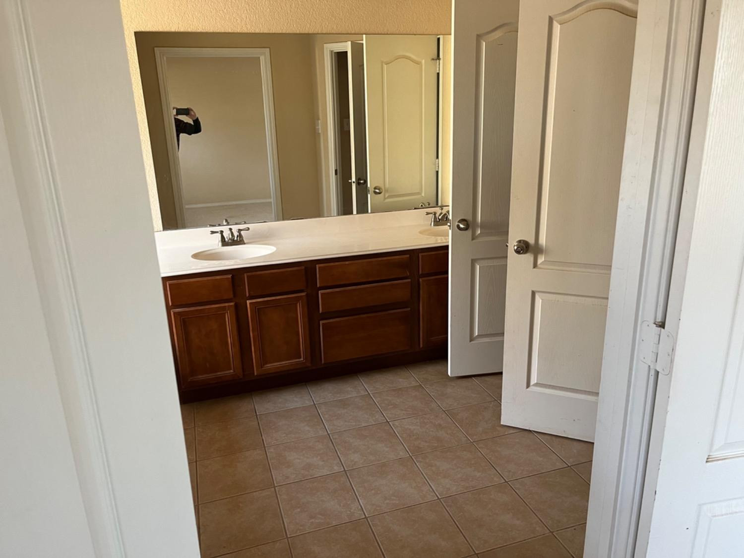 3601 Pontiac Avenue Lubbock, TX 79407 - Photo 5 of 14 a bathroom with a double vanity sink and mirror