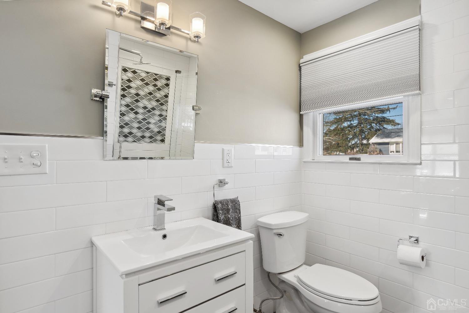 6 Barlow Road Edison, NJ 08817 - Photo 16 of 44 a bathroom with a sink a toilet a mirror and a window