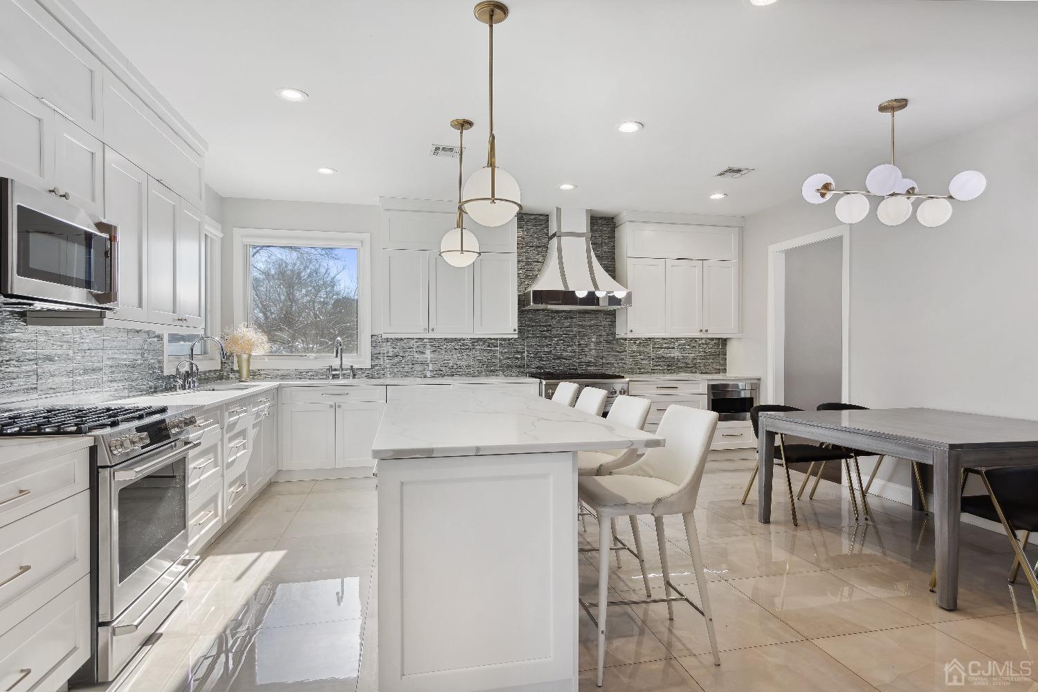 6 Barlow Road Edison, NJ 08817 - Photo 4 of 44 a large kitchen with stainless steel appliances kitchen island granite countertop a stove a sink a dining table and chairs