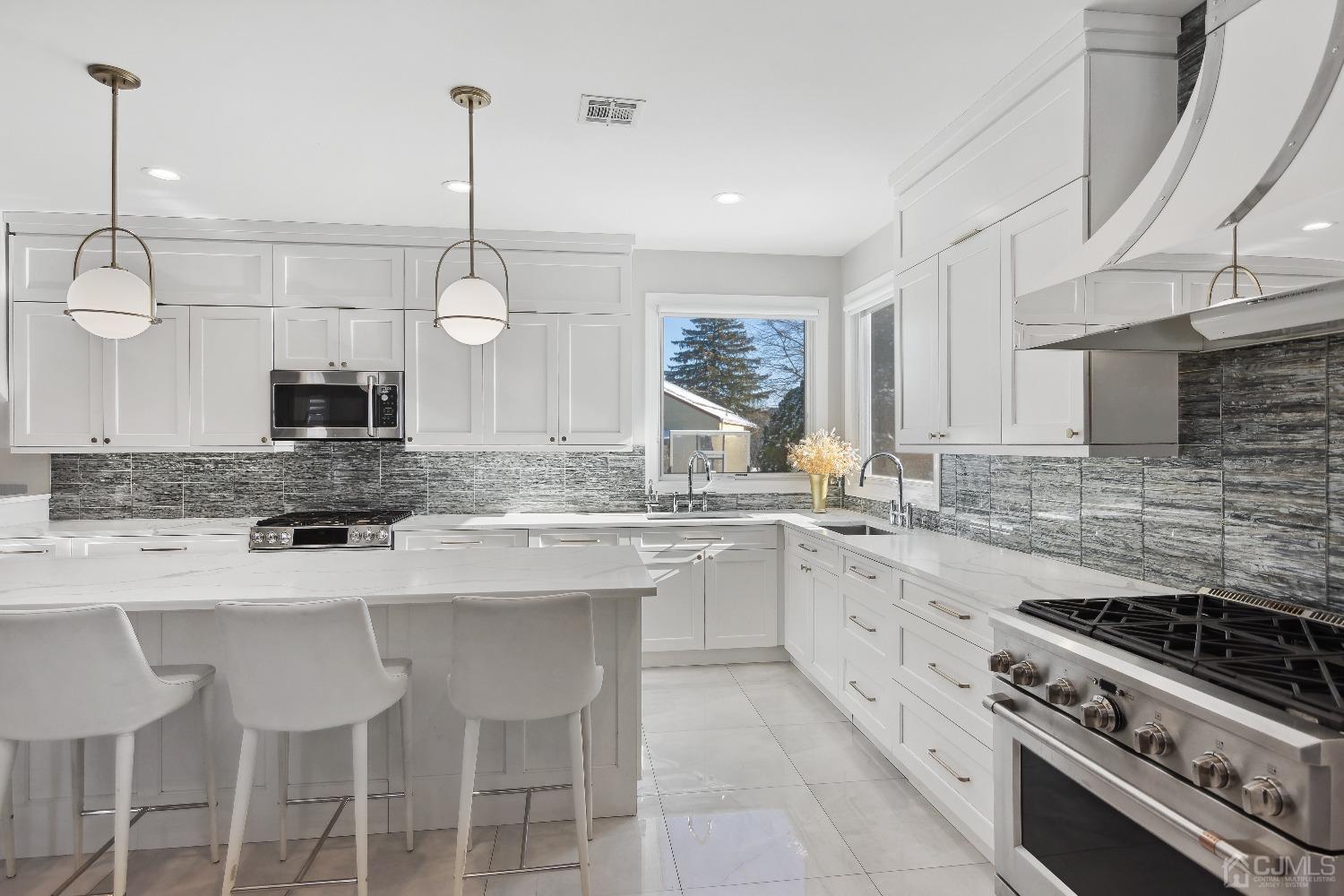 6 Barlow Road Edison, NJ 08817 - Photo 6 of 44 a kitchen with stainless steel appliances granite countertop a sink a stove a microwave a center island and cabinets