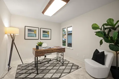 a living room with furniture a window and a potted plant