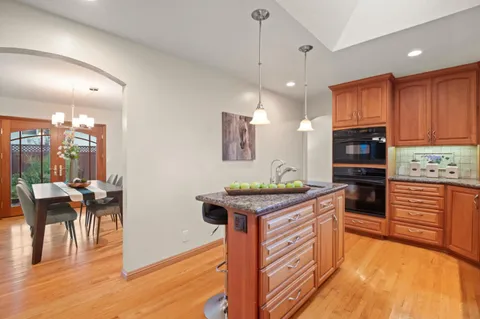 a kitchen with stainless steel appliances granite countertop wooden cabinets a stove top oven a sink and dishwasher