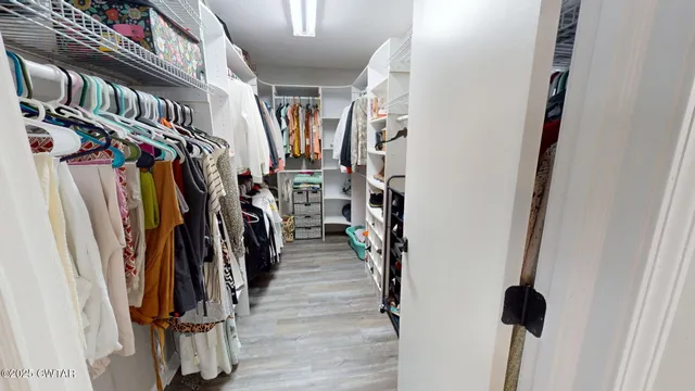 a view of walk in closet with clothes