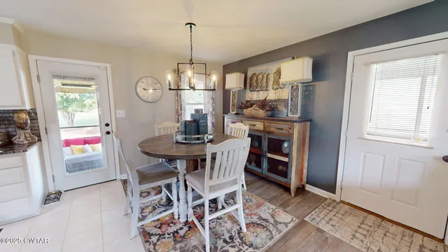 a view of a dining room and livingroom with furniture wooden floor a chandelier