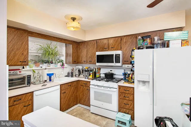 a kitchen with a sink a stove a refrigerator and cabinets