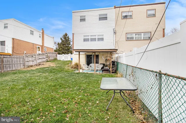 a view of a chair and table in backyard of the house