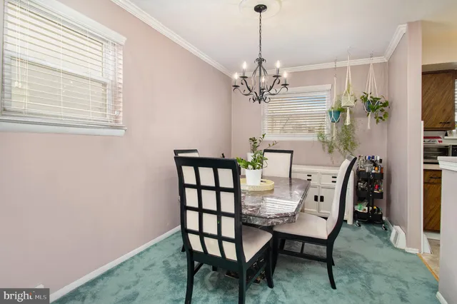 a view of a dining room with furniture and chandelier