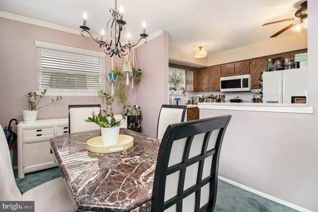 a dining room with furniture a chandelier and window