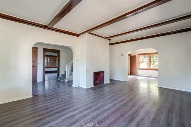 a view of a big room with wooden floor and windows