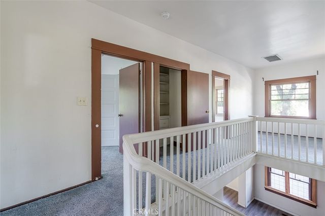a view of hallway with stairs and a window