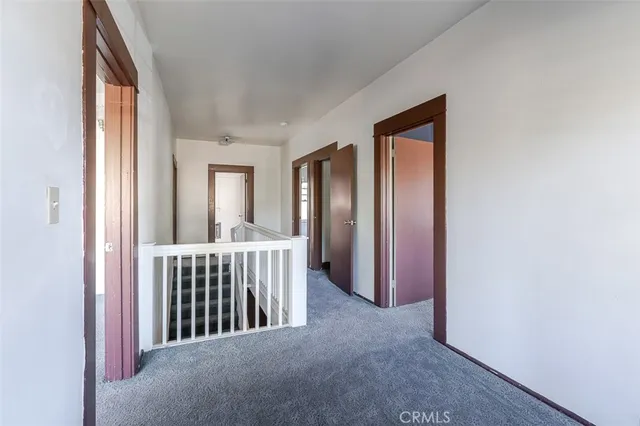 a view of a hallway with a livingroom and a window