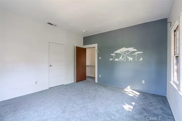 a view of an empty room with chandelier fan