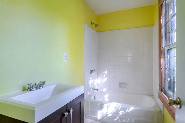 a bathroom with a bathtub sink and a mirror