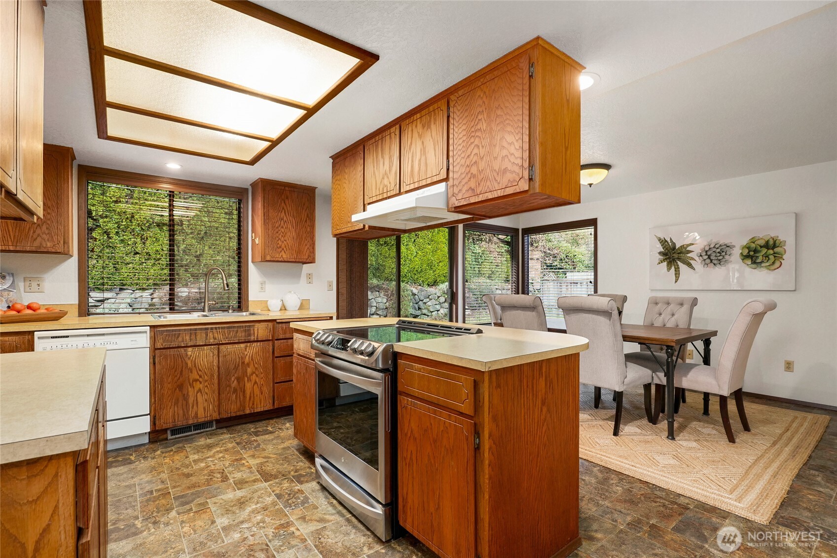 401 169th Street Southeast Bothell, WA 98012 - Photo 12 of 27 a kitchen with a stove a sink a dining table and chairs