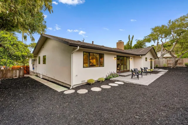 a view of a house with backyard and sitting area