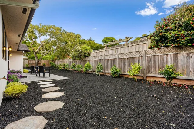a backyard of a house with table and chairs